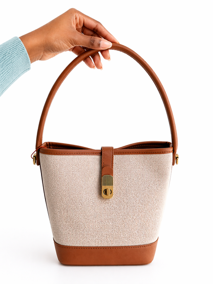 Sac à main en toile beige avec poignée et fermoir doré, idéal pour un style élégant et pratique.